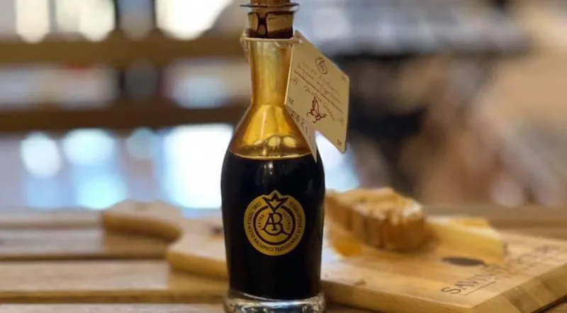 A bottle of aged balsamic vinegar on a wooden tasting board