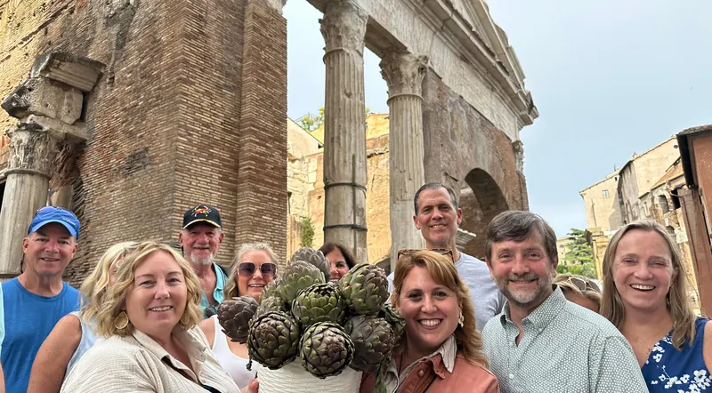 A food tour group with artichokes in front of the Portico of Octavia in Rome