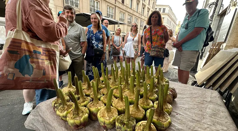 A tray of Roman artichokes in front of a food tour group in the Jewish Quarter