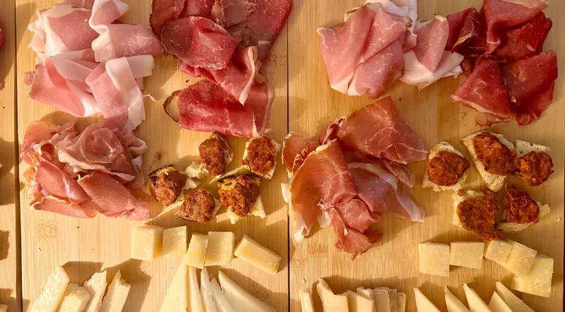 Two wooden boards of prosciutto, salami and sliced cheeses for a Rome wine tasting