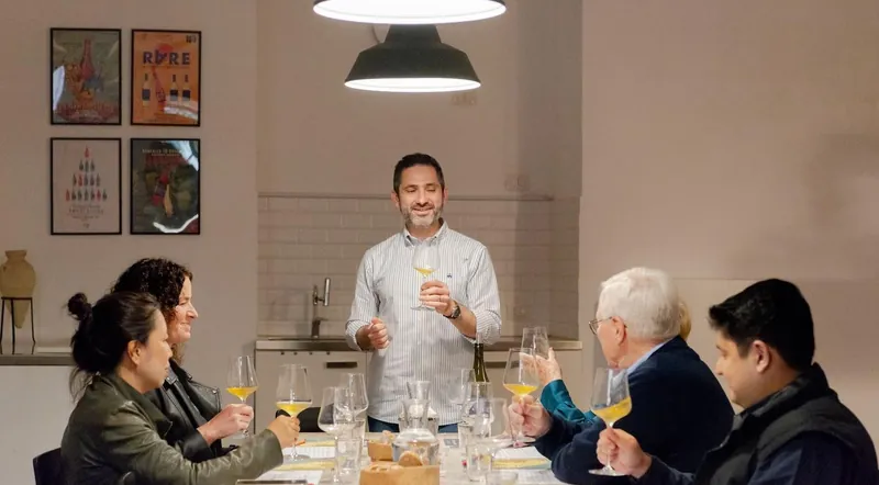 A sommelier leading a seated wine tasting for a small group in Rome