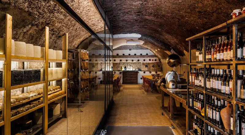 A glass-walled cheese maturing cave inside an ancient vaulted cellar in Testaccio