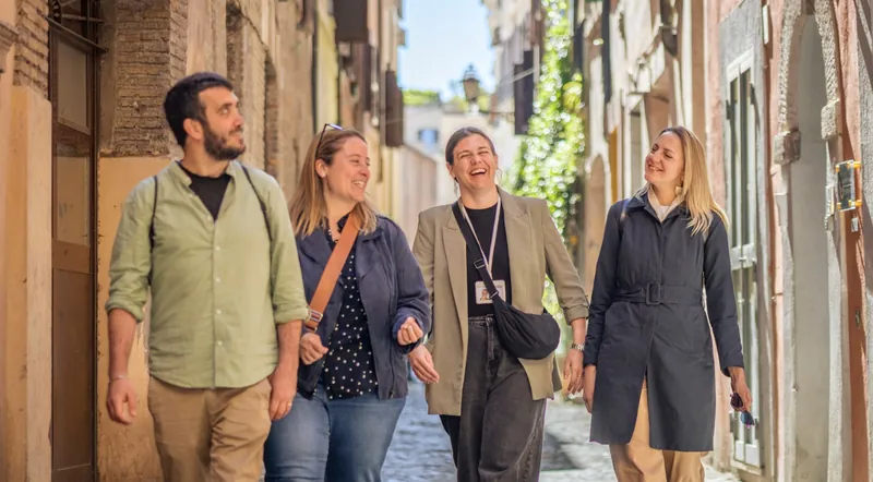 A guide walking a small group down a narrow cobbled street in Trastevere