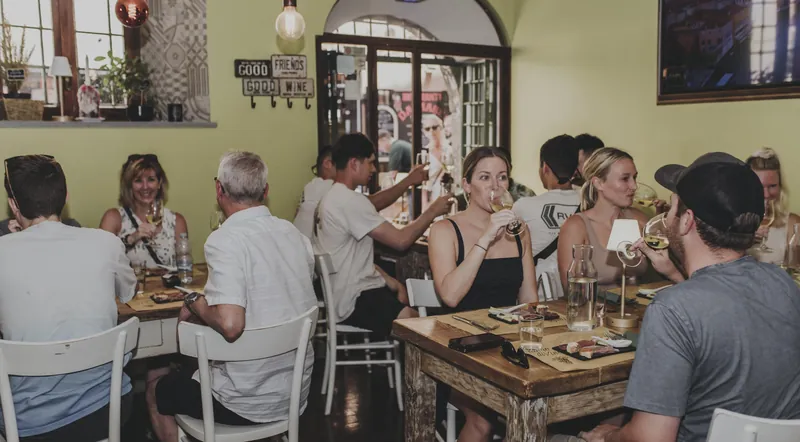 Guests tasting wine and food at a busy Trastevere wine bar
