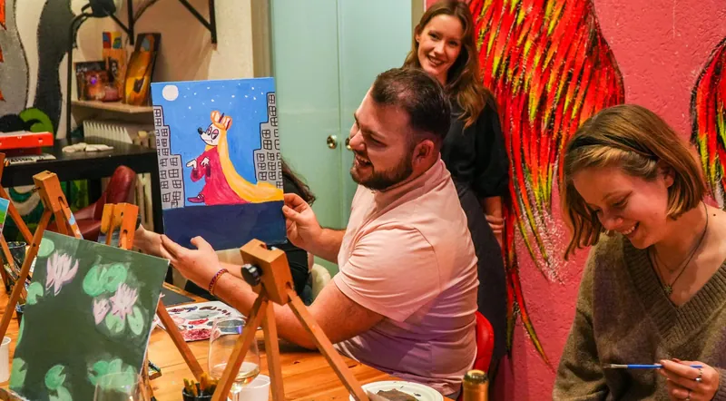 Guests painting on canvases with glasses of wine at an evening class near Piazza Navona